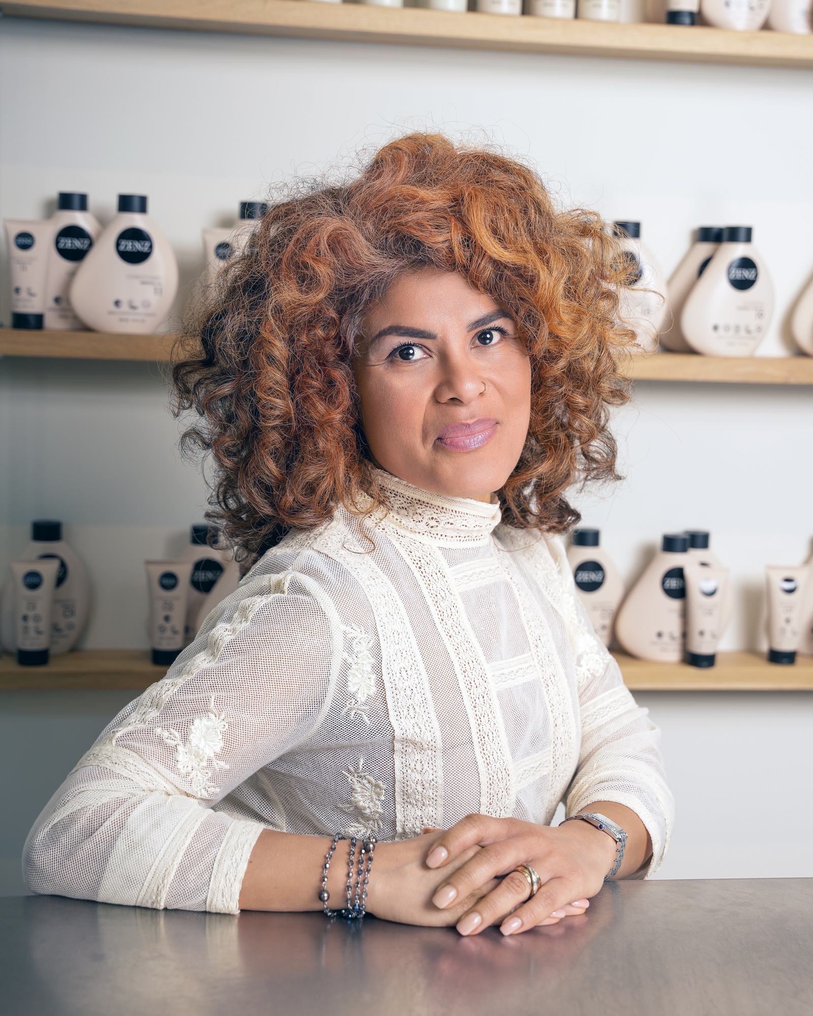 Flor, oprichtster van FLOR, aan de balie van de salon voor de productwand